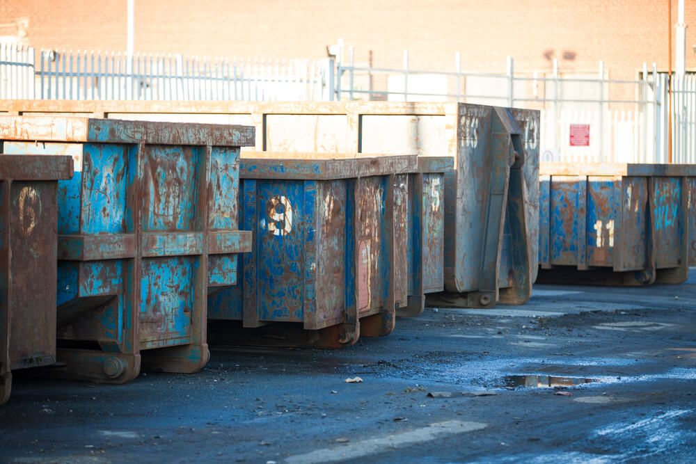 a long shot of a bunch of commercial skip hire bins in our local yard