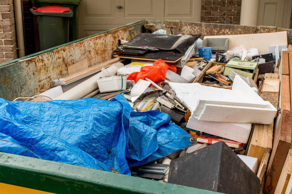 close up view of a residential skip hire bin filled with general house hold rubbish and waste